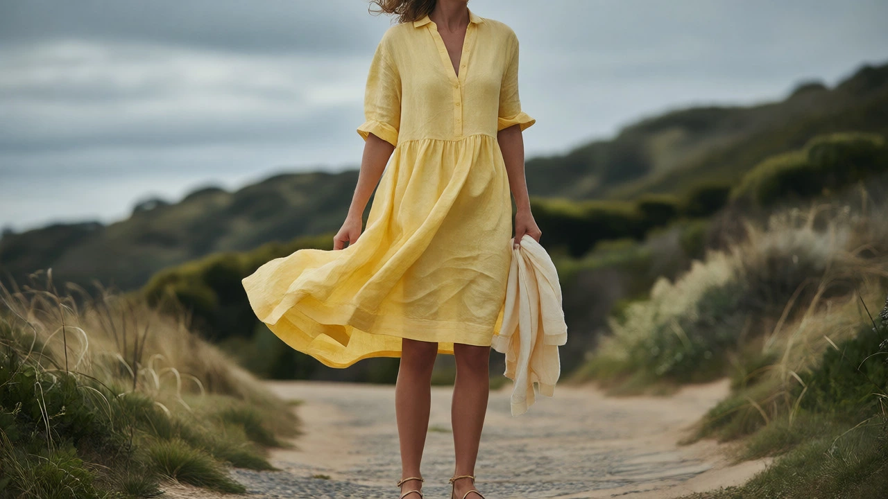 Woman in flowing yellow linen dress on windy coastal path